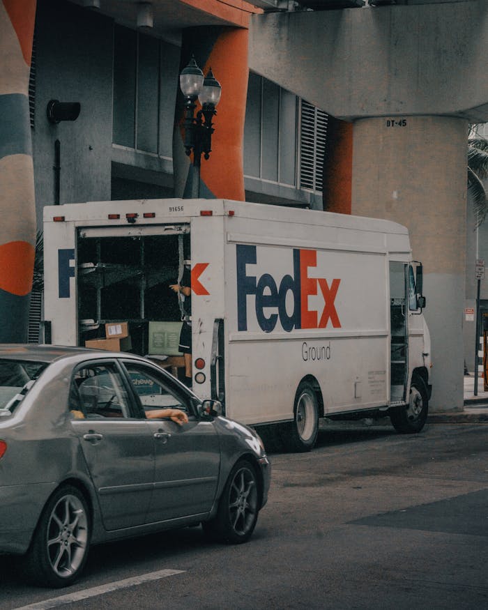 FedEx delivery truck unloading packages on a busy city street. Urban logistics and transportation concept.